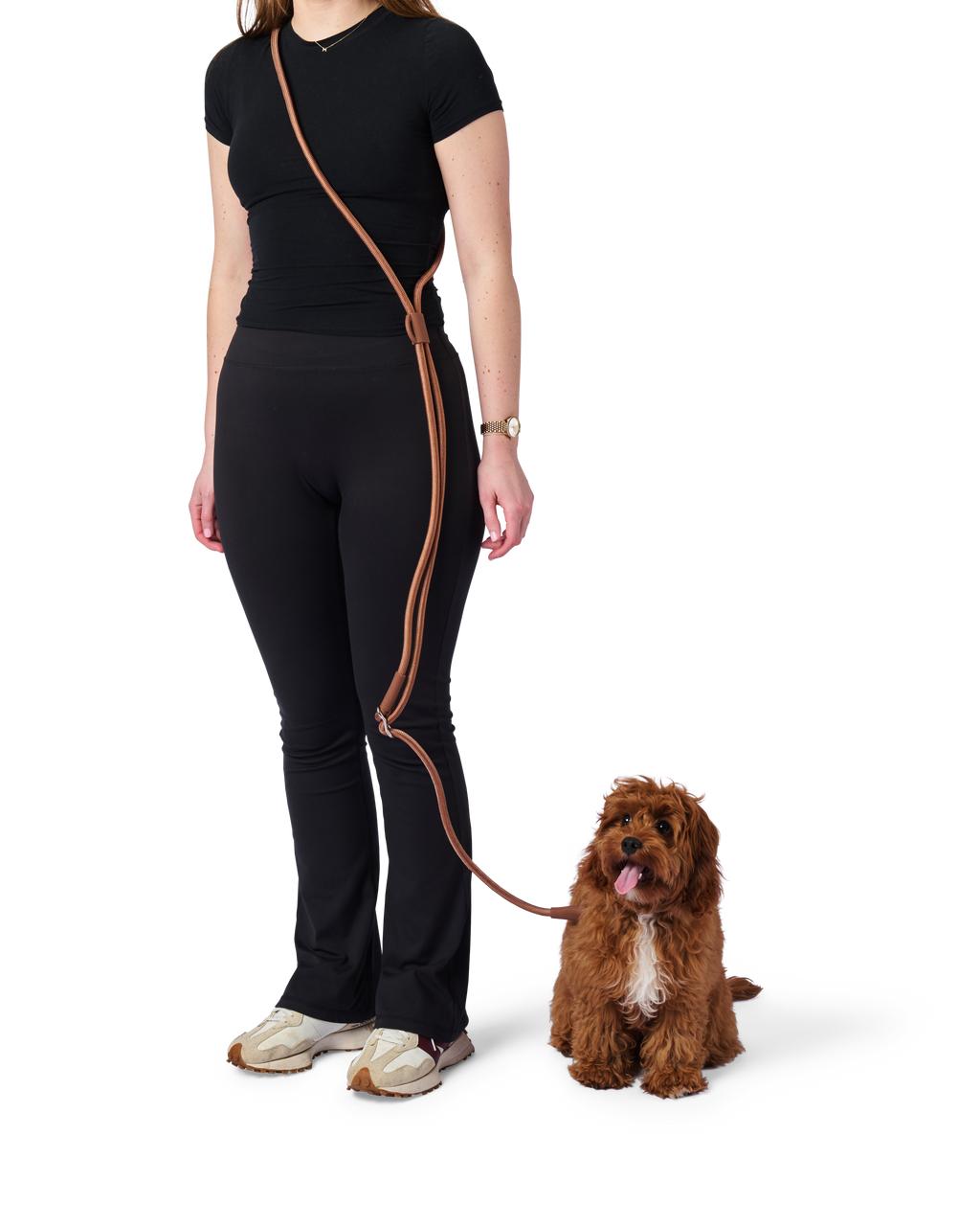 Woman in black outfit with brown leash standing next to a dog on a white background